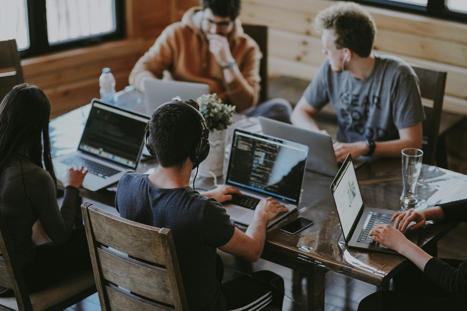 Marketing team collaborating around a table with laptops